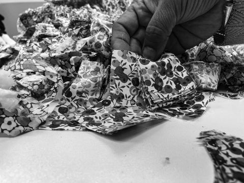 Photo d'un tas de chutes de tissus et de déchets textiles. Les plus petites chutes sont broyées pour fabriquer notre matelassage Azala, les chutes plus grandes sont découpées en carrés identiques pour fabriquer le patchwork de nos gilets. Photo prise dans l'atelier "Les Petites Chutes", à Madagascar. 